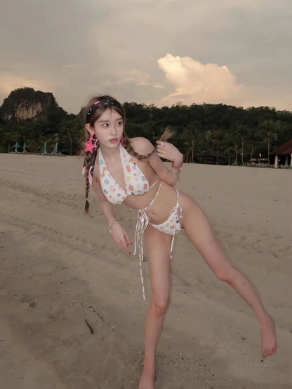 Woman in a Hello Kitty bikini standing on a beach with mountains in the background